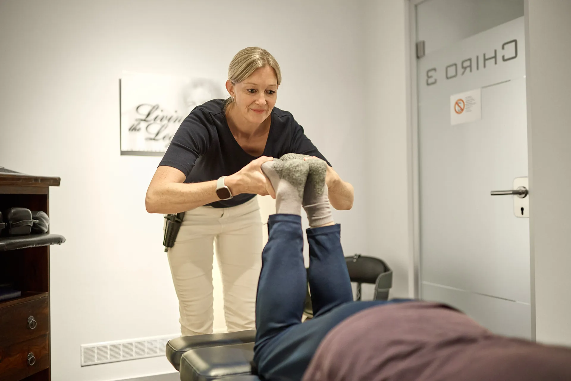Behandlerin mobilisiert die Beine einer Patientin in der Praxis Dr. Thiele