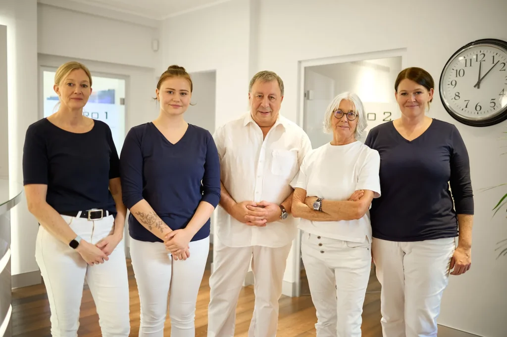 Das fünfköpfige Team der Praxis Dr. Thiele im Flur der Praxis in München